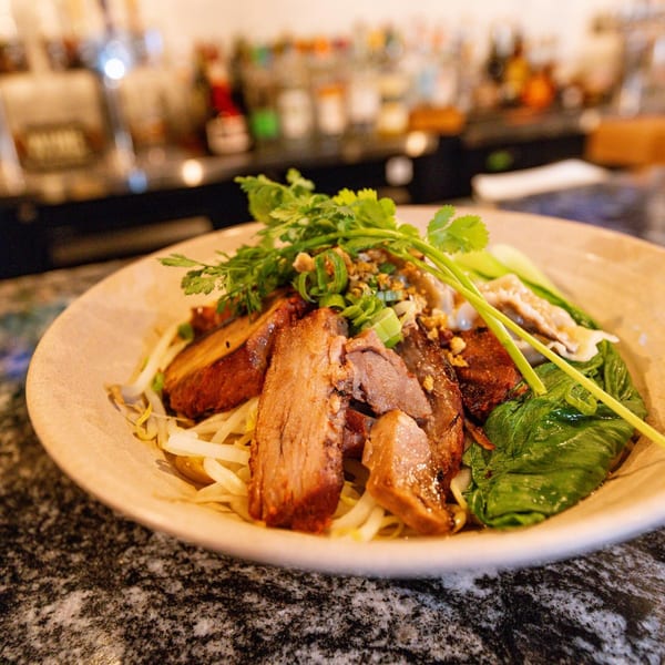Bleu Ginger's Asian-fusion dish with sliced meat, noodles, bean sprouts, and fresh herbs.